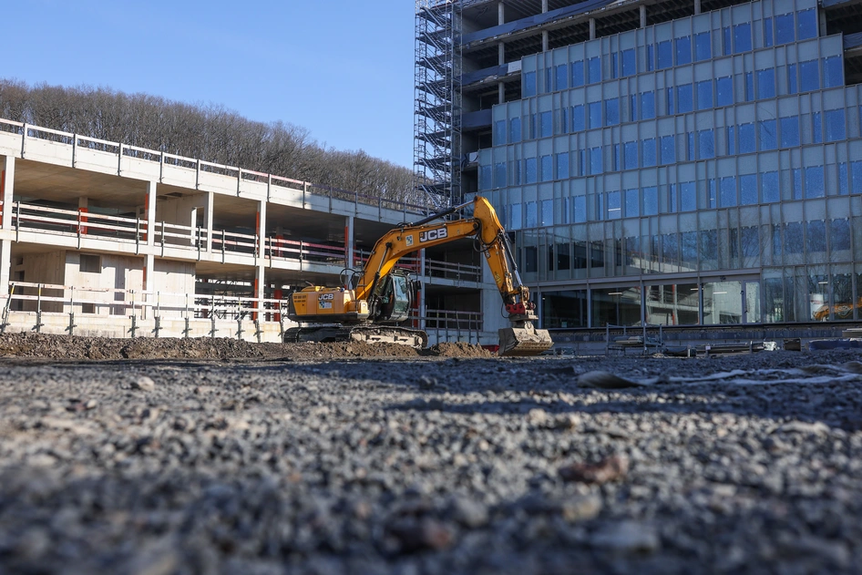 Bagger mit Kran und Grundstück